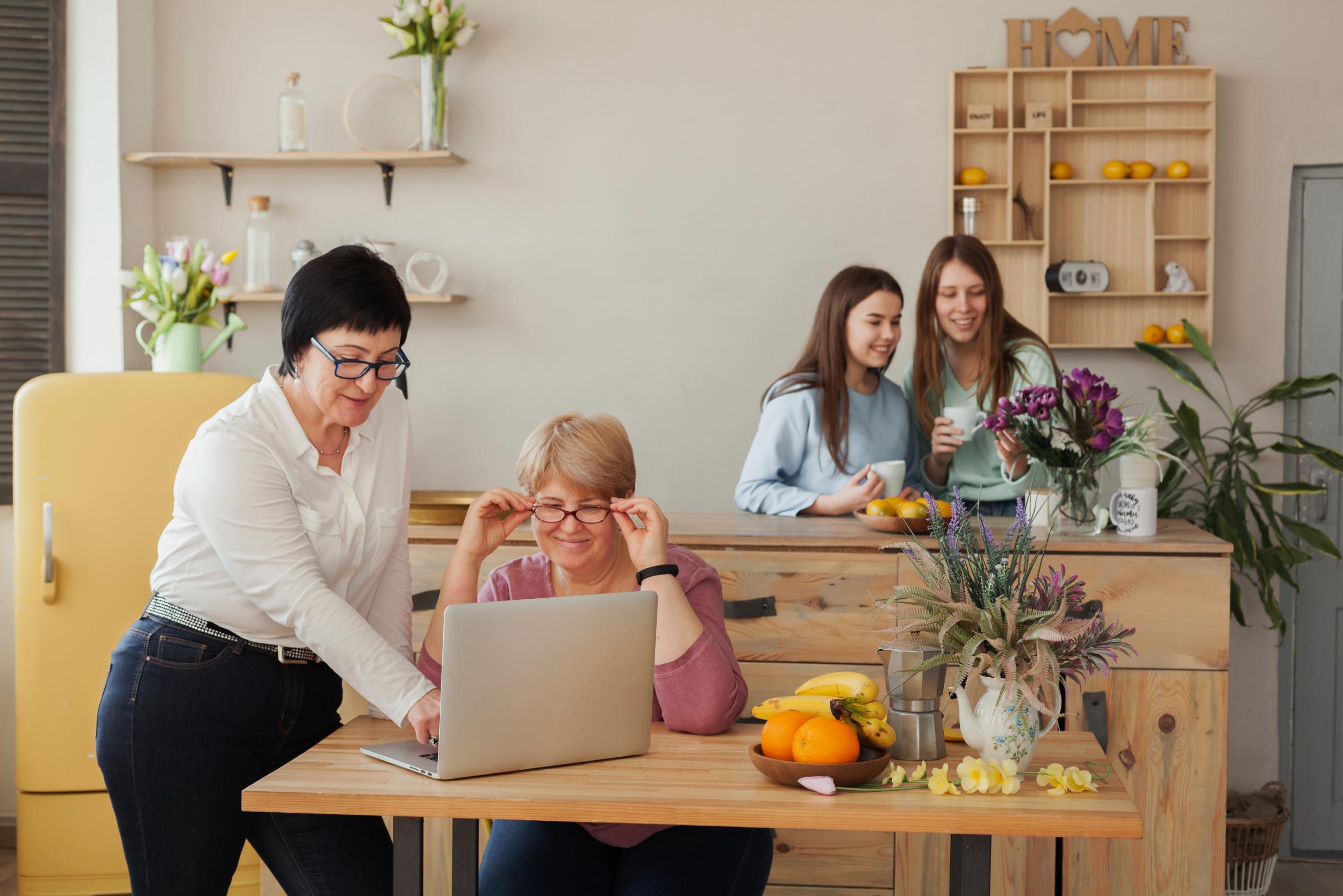 First-time homebuyer reviewing mortgage information with a housing advisor while family members gather in the background.