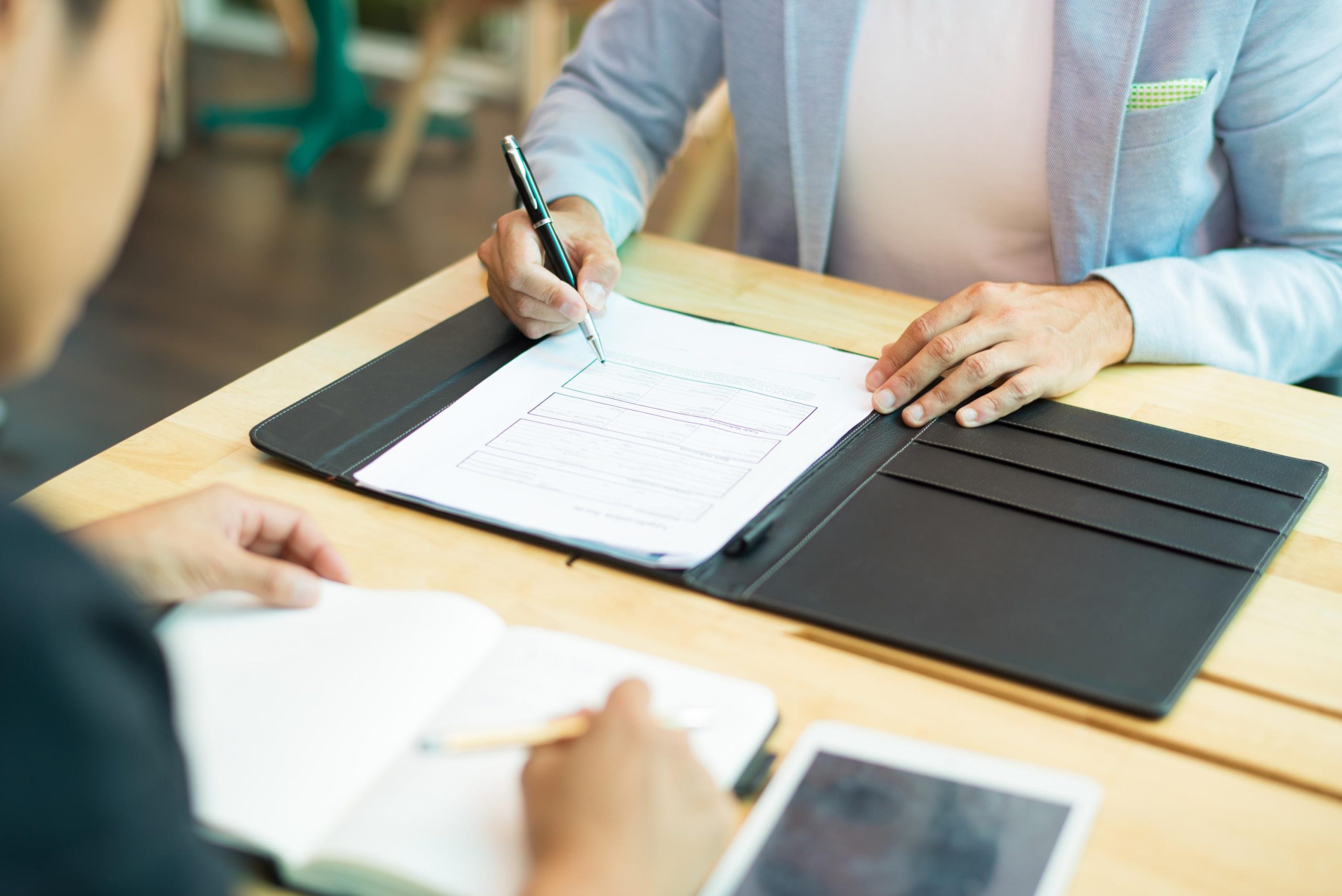 Mortgage professional explaining a VA Certificate of Eligibility document to a homebuyer during a loan consultation.