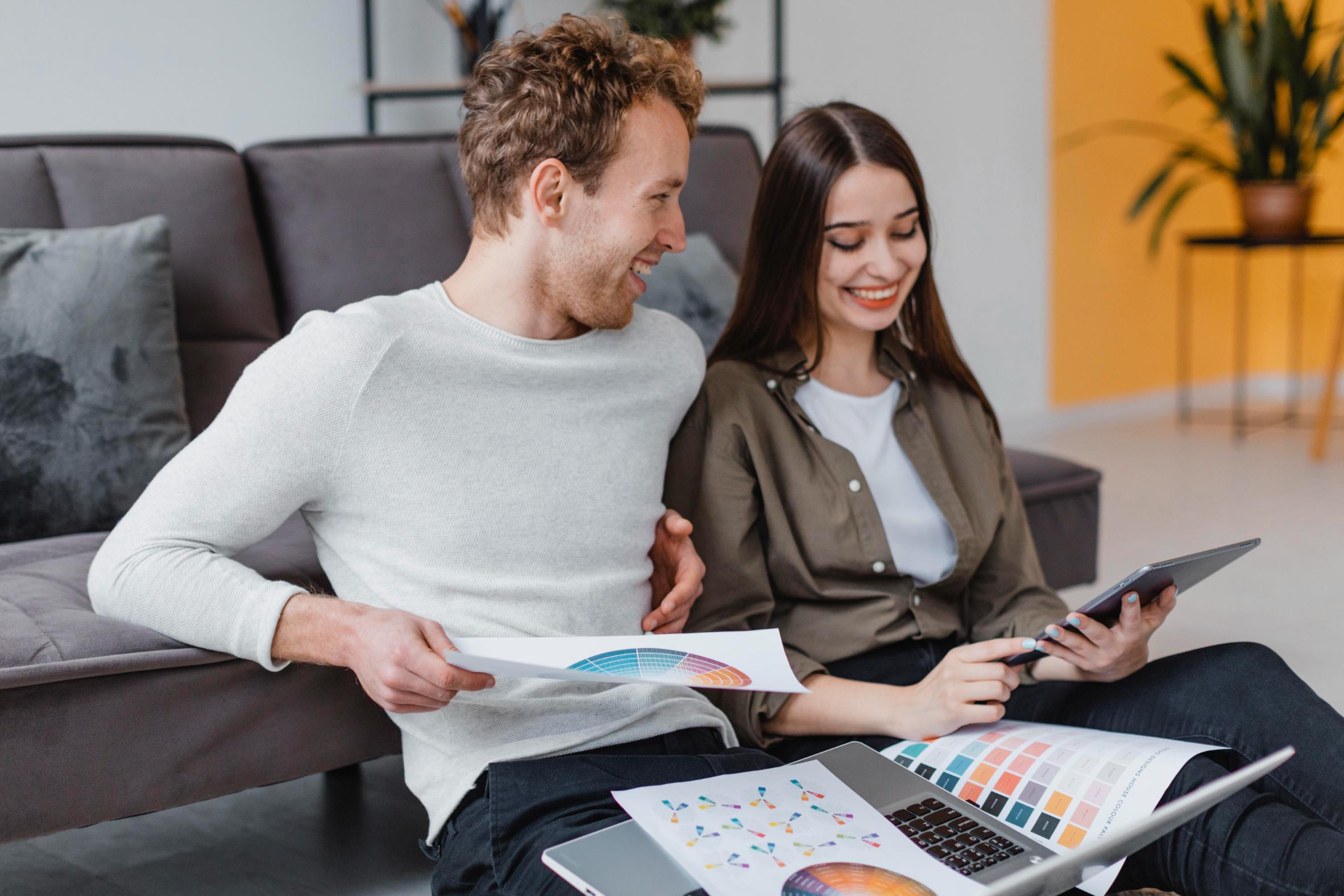 Couple reviewing finances and home improvement plans while exploring a Texas cash-out refinance option using a tablet and financial documents.