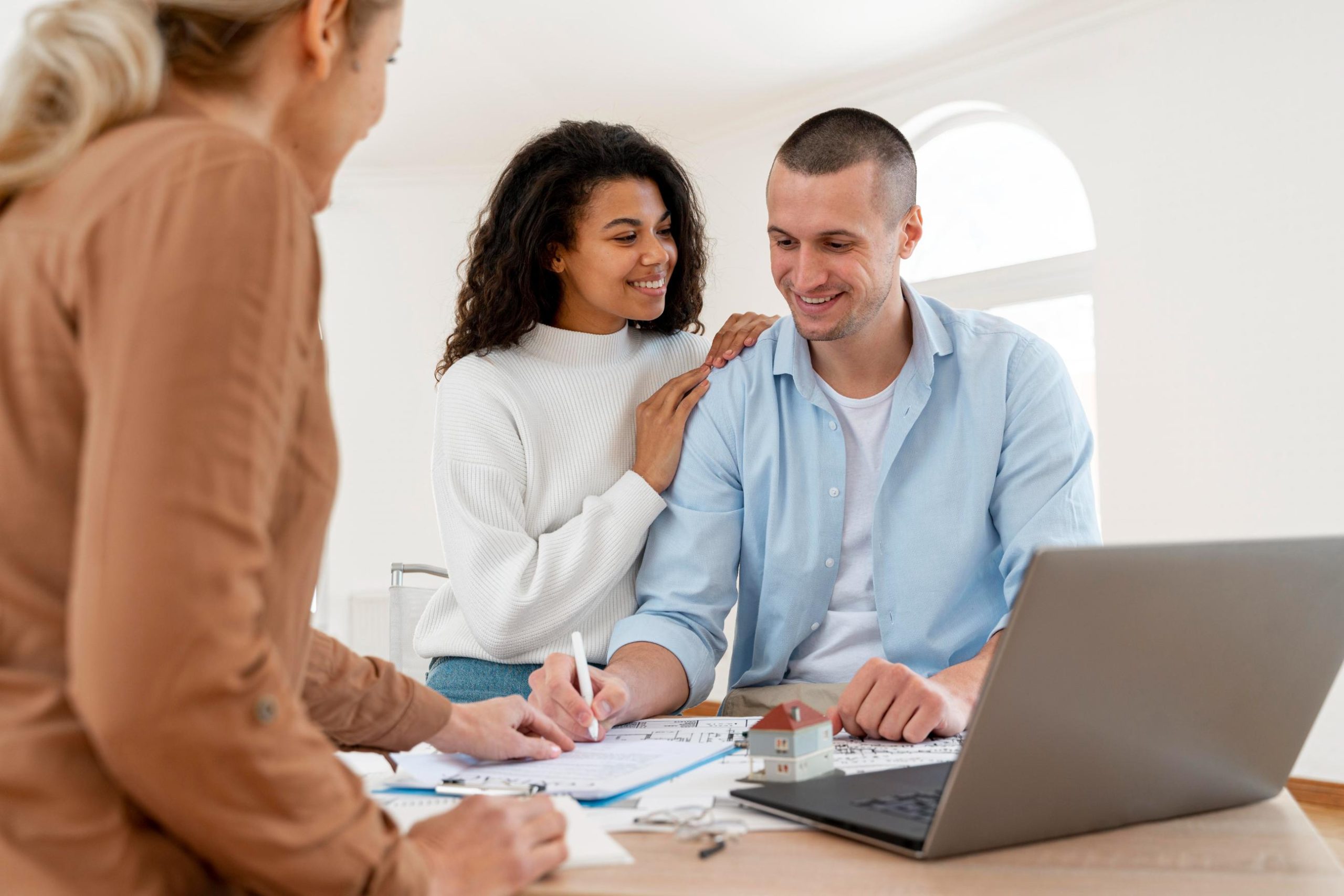 Texas mortgage broker assisting a couple with a home loan application, reviewing mortgage documents and financing options at a consultation.