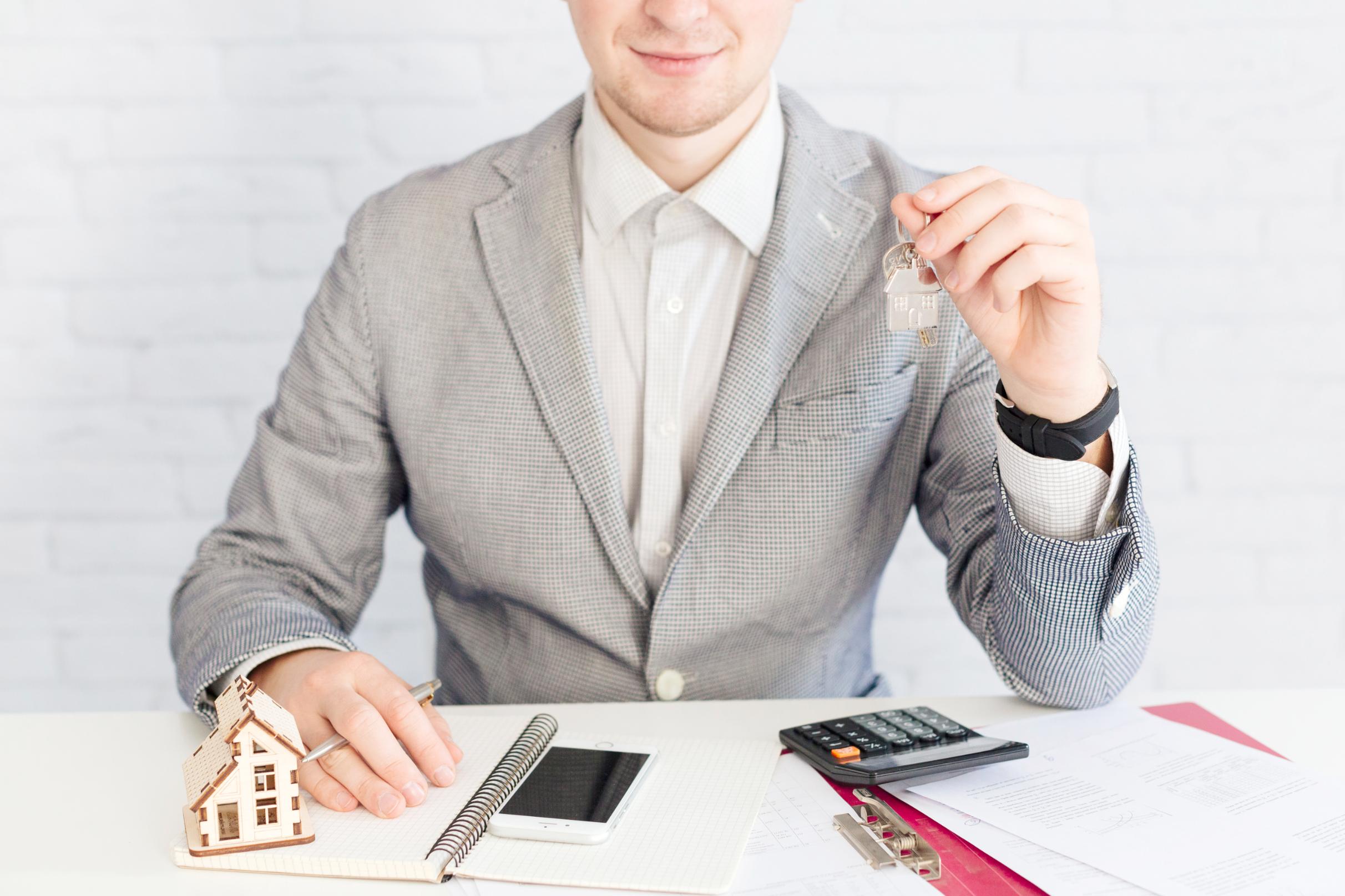 Real estate investor reviewing financing documents and holding house keys for an investment property loan in Texas.