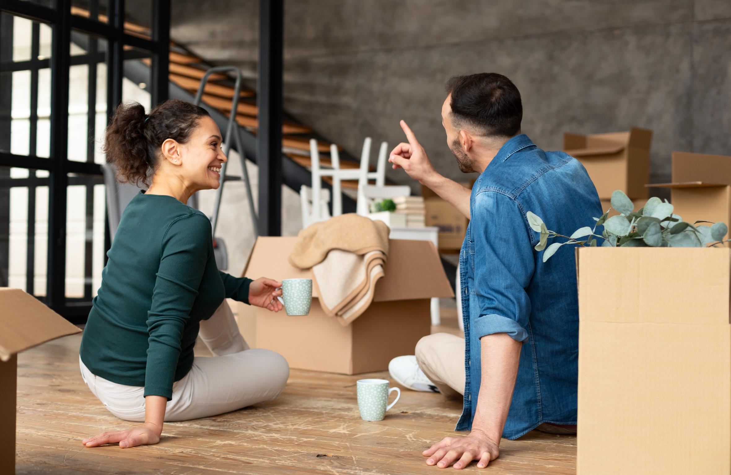 First-time homebuyers in Texas relaxing in their new home surrounded by moving boxes after purchasing a house.
