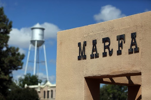 Historic Marfa, Texas city sign with water tower in the background, symbolizing small-town charm and rural lifestyle—perfect for affordable home loans, refinancing, and mortgage options in Marfa, TX.