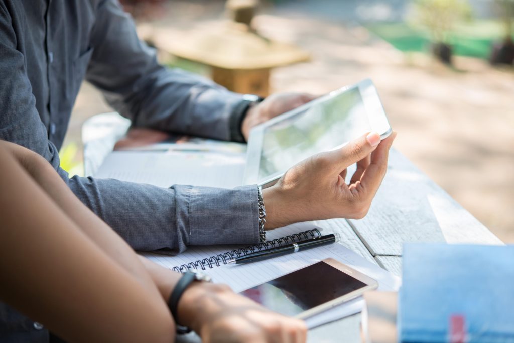 Homebuyers researching USDA Home Loans in Cedar Park on a tablet with documents and notes