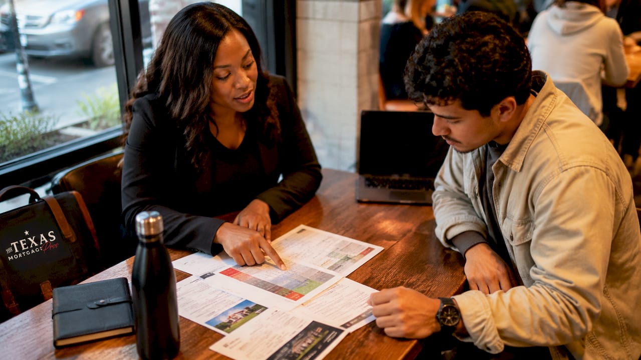 Texas mortgage broker reviewing loan options and mortgage documents with a homebuyer during a one-on-one consultation.