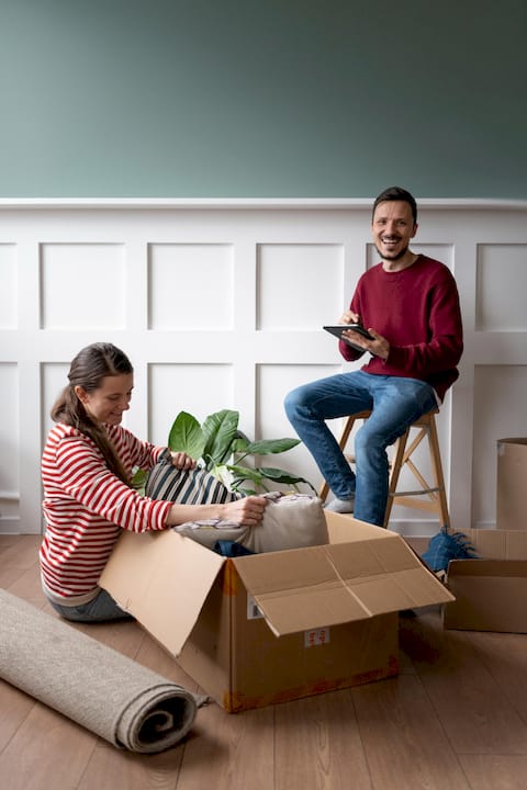 Spanish-speaking homeowners organizing their new space after completing a home purchase or refinance in Texas