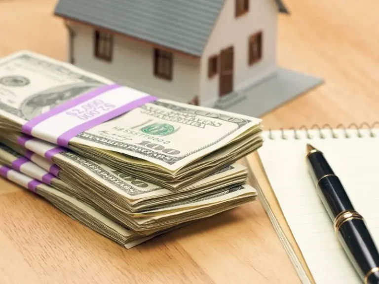 Stacks of cash beside a model home representing HELOC funds and access to home equity.